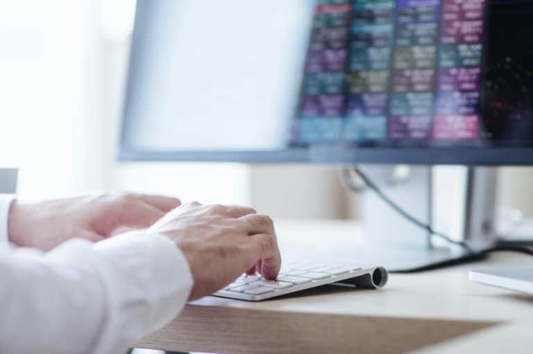 Personne analysant des graphiques financiers sur un ordinateur
