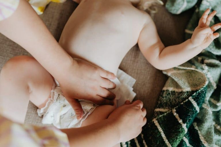 Fesses de bébé irritées avec des couches Pampers en arrière-plan